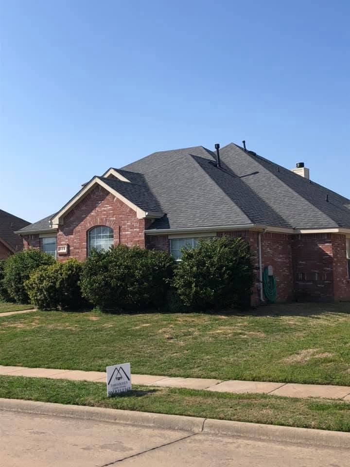 Completed roofing project with a Whitetail Roofing yard sign